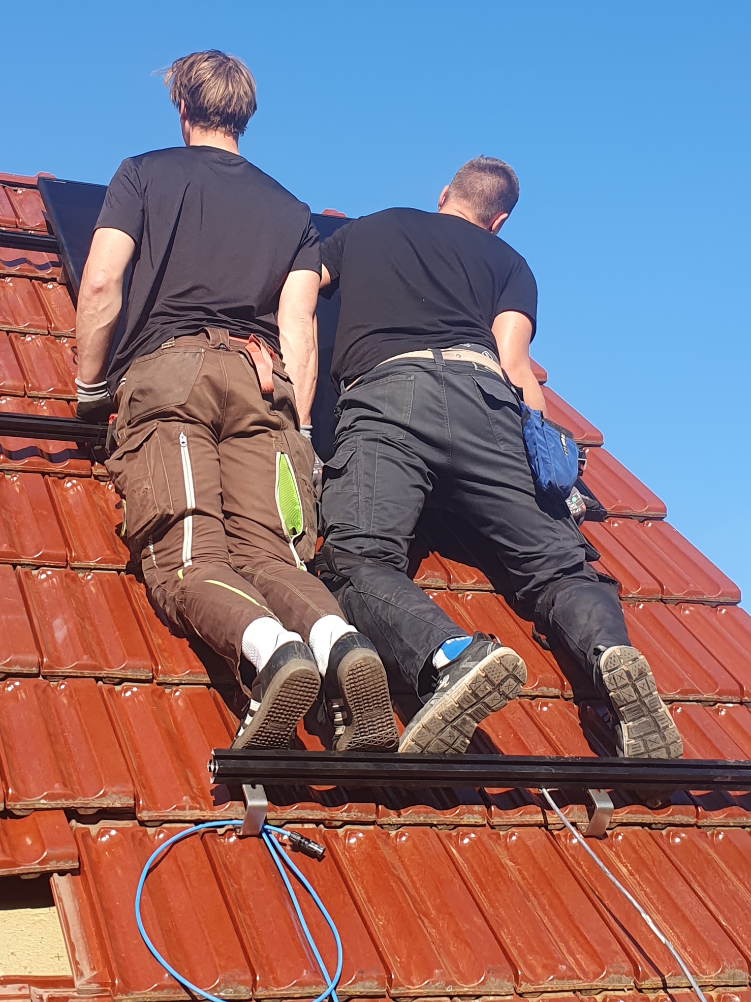 Photovoltaik-Monteure bei der Installation von Dachmodulen