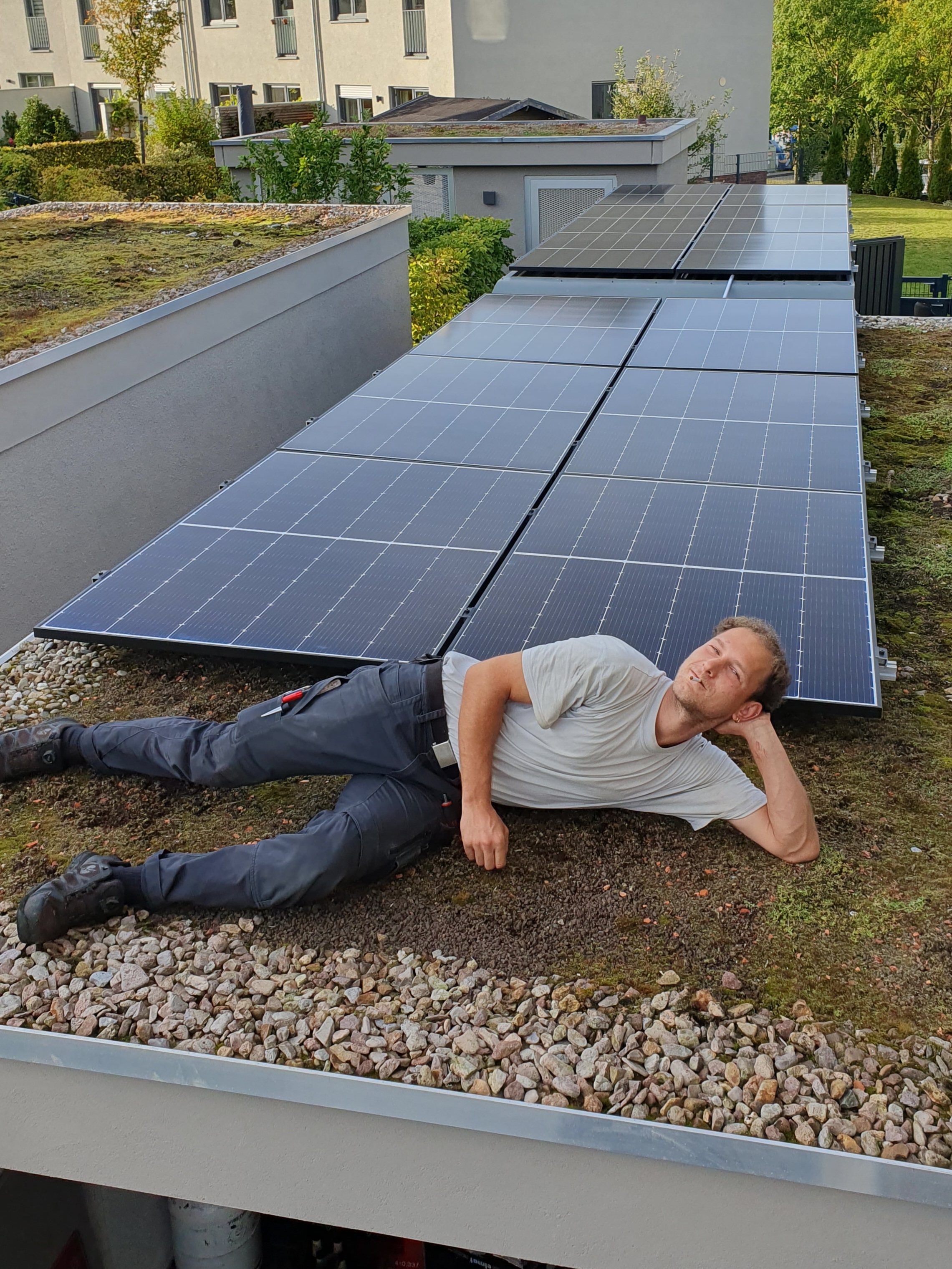 Mitarbeiter entspannt neben installierter Photovoltaikanlage